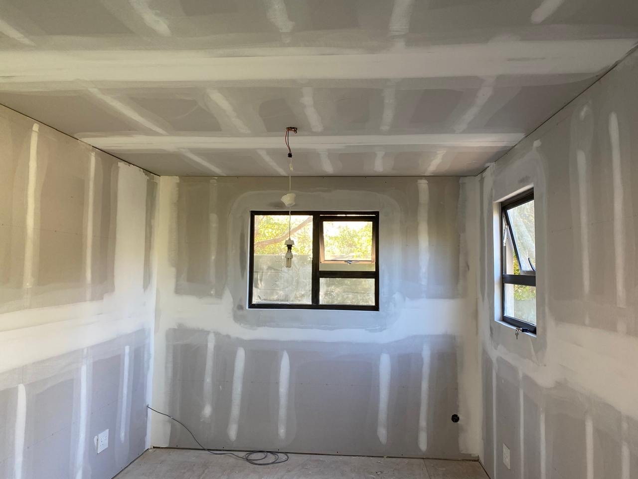 Room with drywall joints taped and mudded, ready for skimming