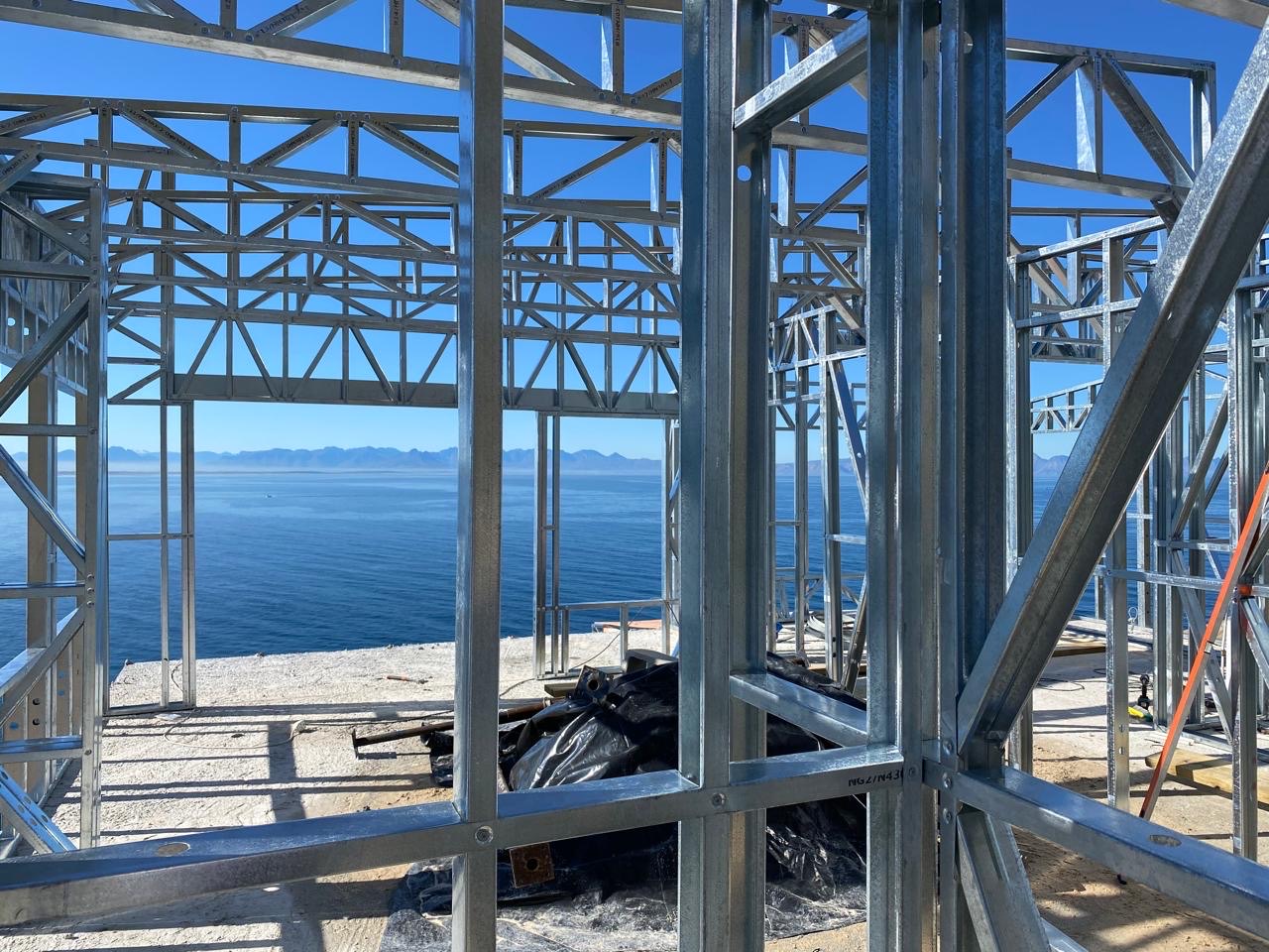 View through an erected Zincalume light steel frame to the sea and mountains
