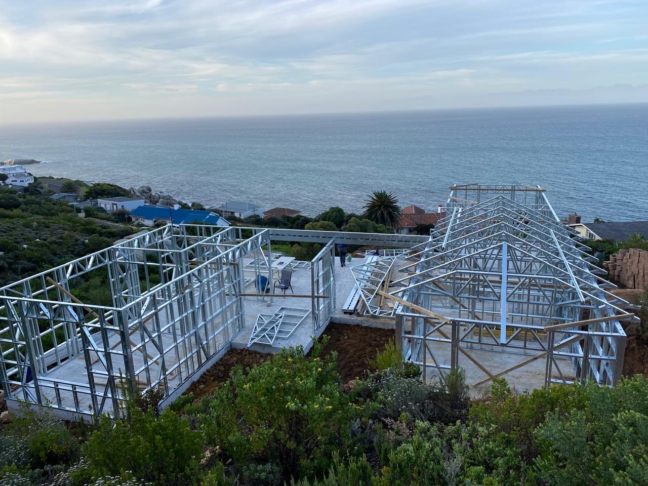 Complete light steel frame with walls and roof trusses on a sea-facing hillside site